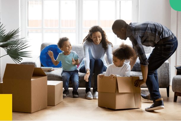Family happily unpacking moving boxes in a new home